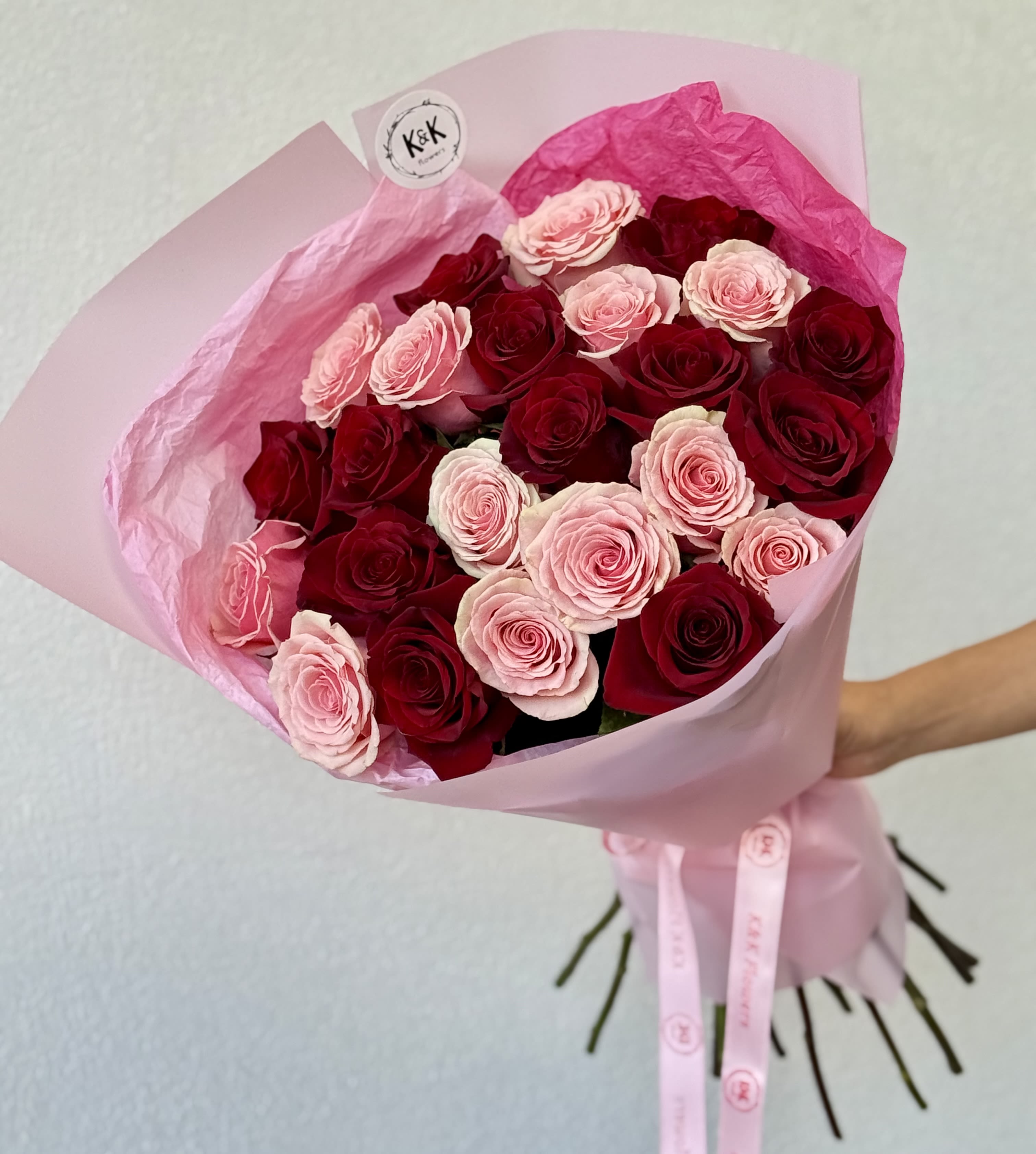 Bouquet of pink and red roses wrapped in pink paper