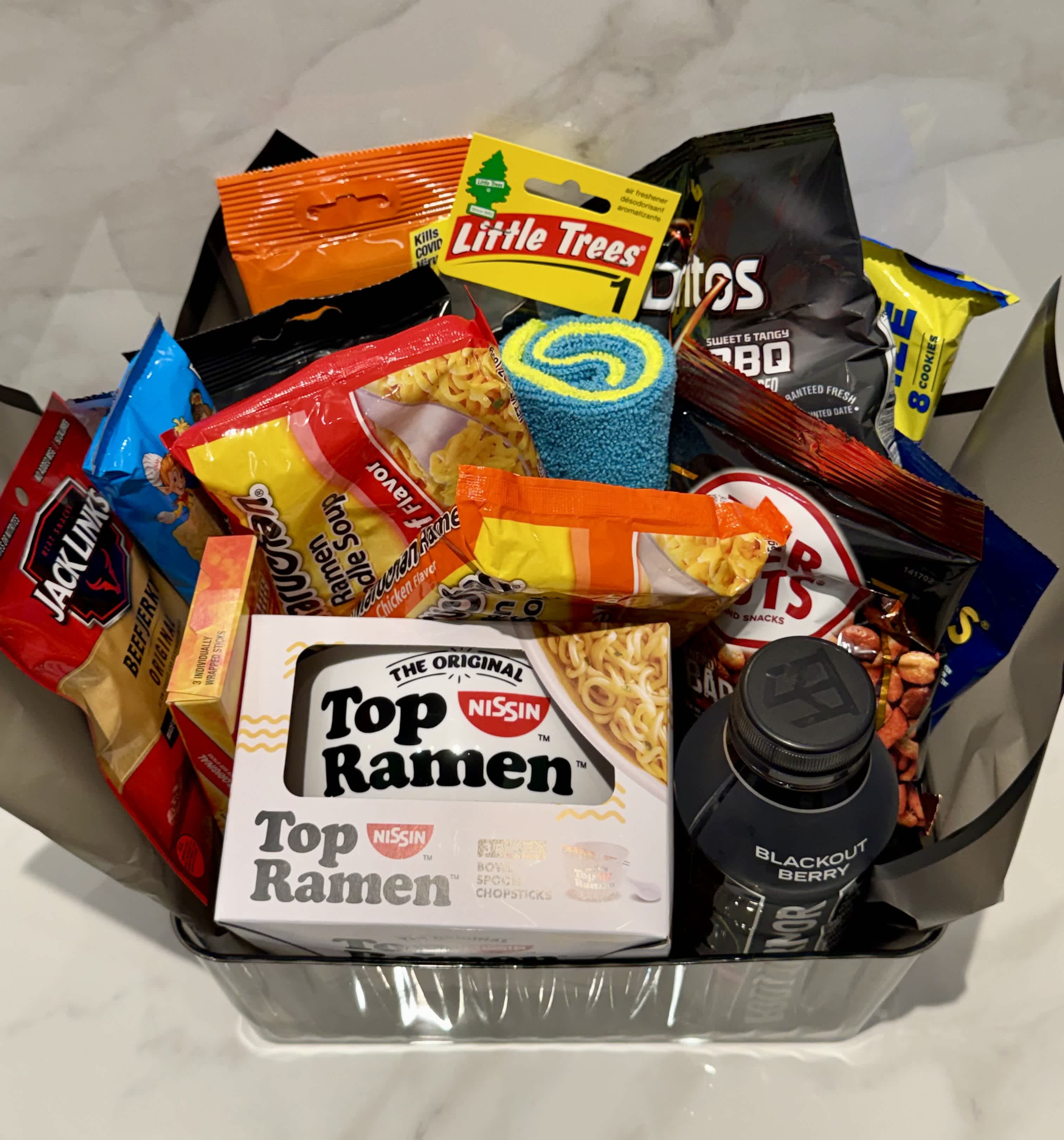 Gift basket filled with snack bags, ramen, and a drink bottle