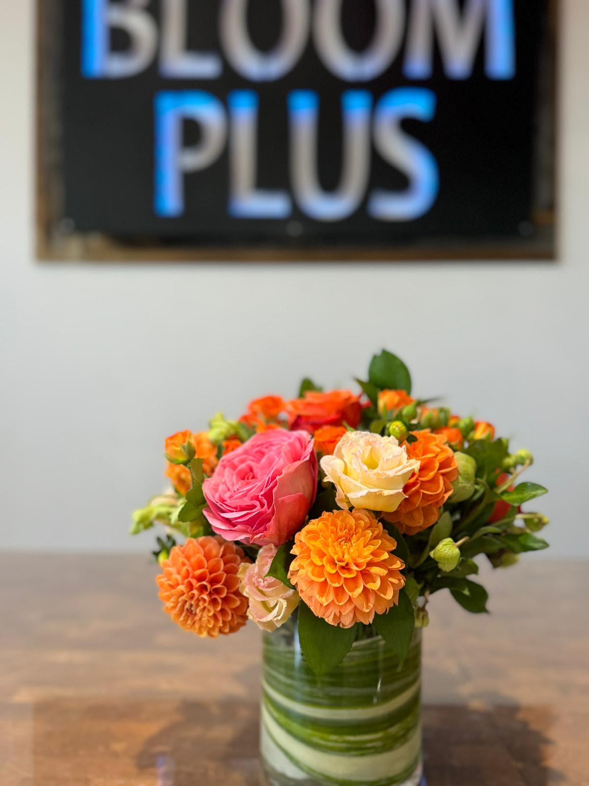 Orange and pink flowers arranged in a glass vase