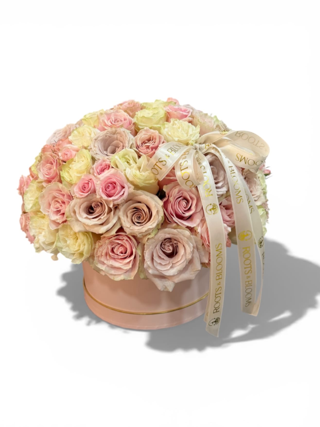 Round bouquet of pastel roses in a pink hat box with ribbon