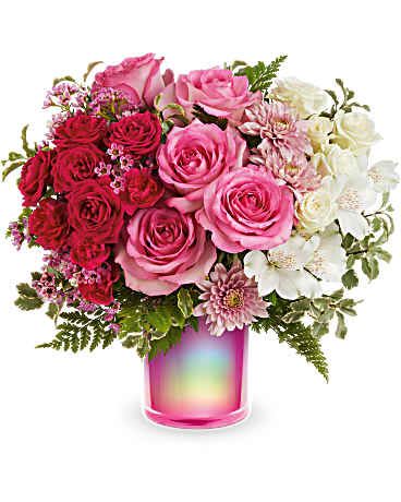 Pink and red roses with white flowers in a pink glass vase