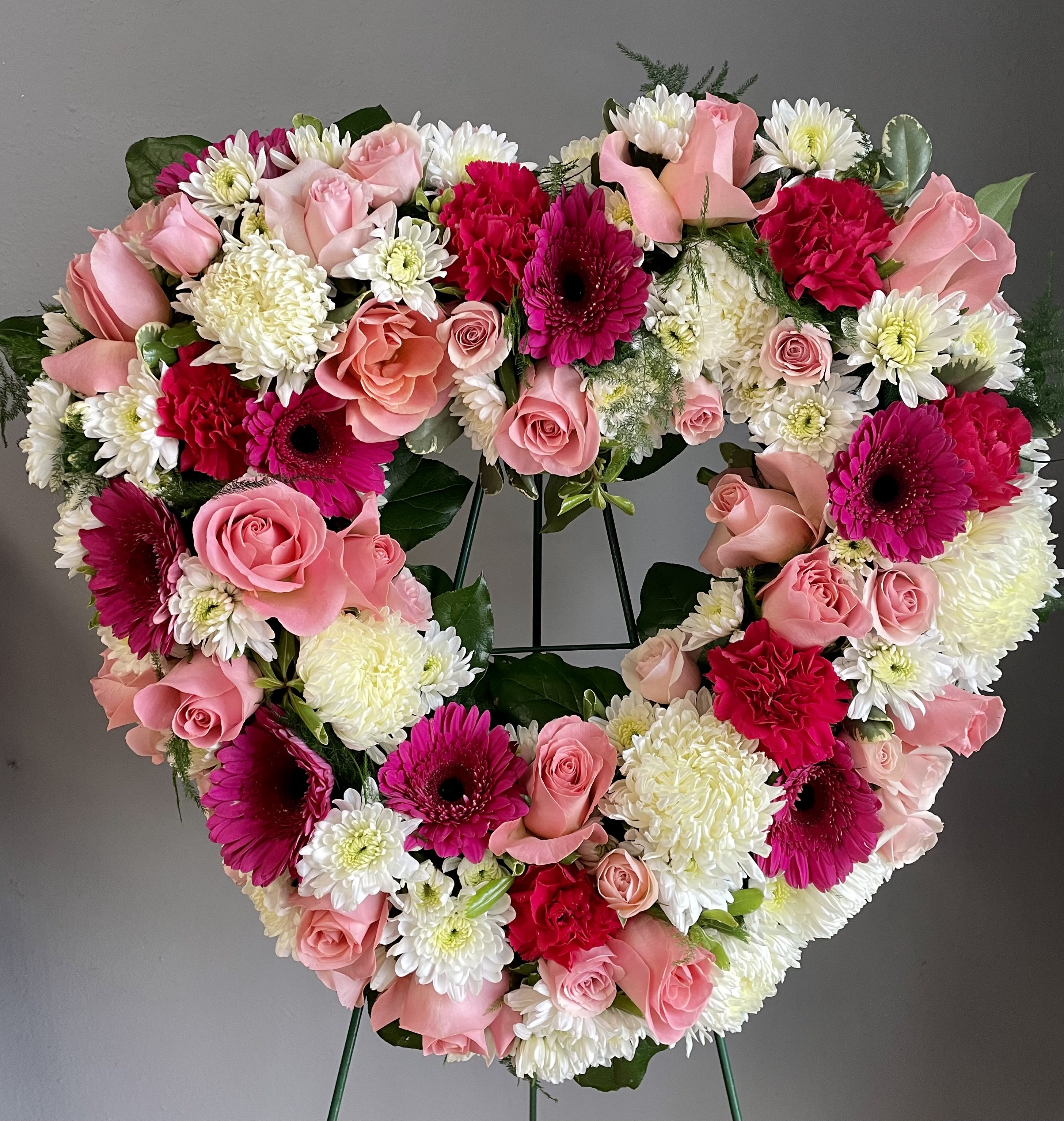 FUNERAL HEART WREATH - Loving Heart 68 - This is a beautiful option for a funeral service, church or graveside. This open heart arrangement will be designed with an 18”, 24" or 30" heart form and will be delivered on a stand. This lovely mix of white and pink flowers of roses, daisies, chrysanthemums and gerbers is a gorgeous piece to add some beautiful color for a beautiful life.   **This is a piece for a funeral or memorial service. Please place the order at least 2 days prior to the service to guarantee a certain arrangement. Anything sooner and we cannot guarantee it will match the picture. These pieces can be customized to the color of your choice. The flowers may vary depending on availability of the flowers, special requests and quality of the flowers we have in stock. If you have a special request please add it to our special instructions when placing your order. If you have any questions please don’t hesitate to call. 714 289 1123**