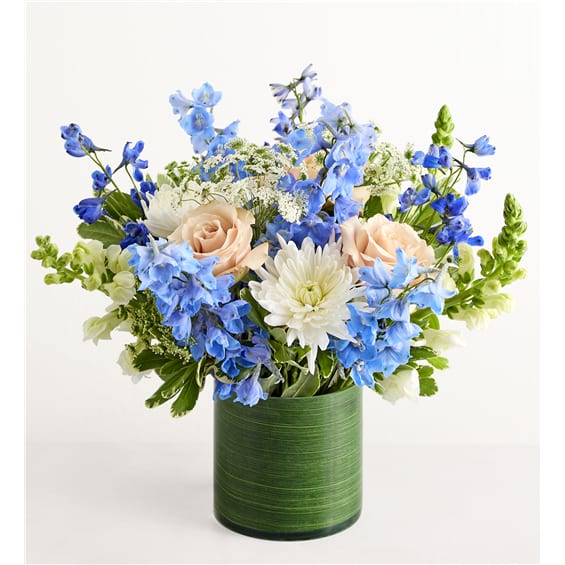 Blue and white flower arrangement in a green vase