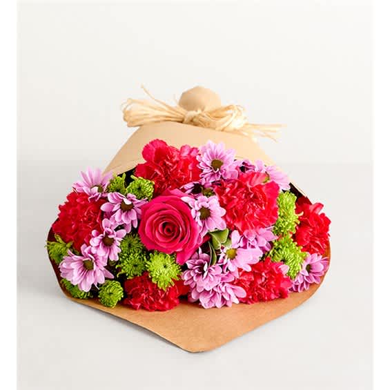 Bouquet of pink, red, and green flowers wrapped in brown paper