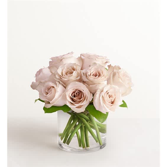 Pale blush roses arranged in a clear glass vase