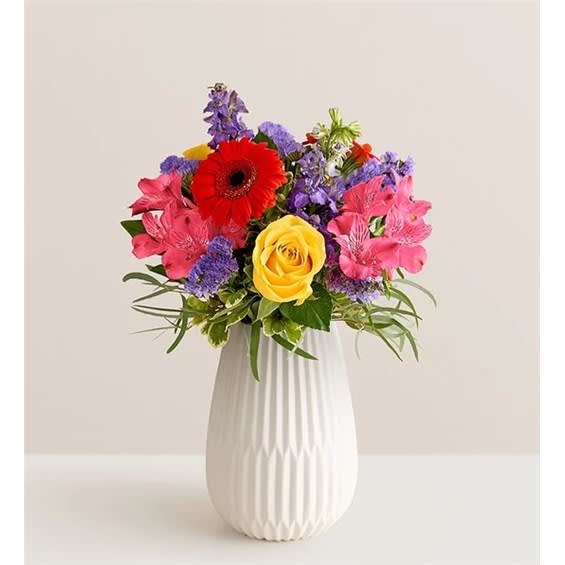 Colorful bouquet in a white vase with a red gerbera and yellow rose
