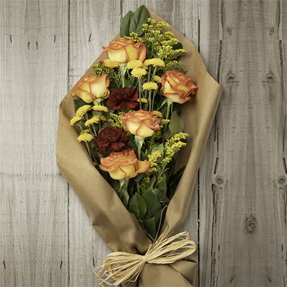 Bouquet of orange roses and red carnations wrapped in brown paper