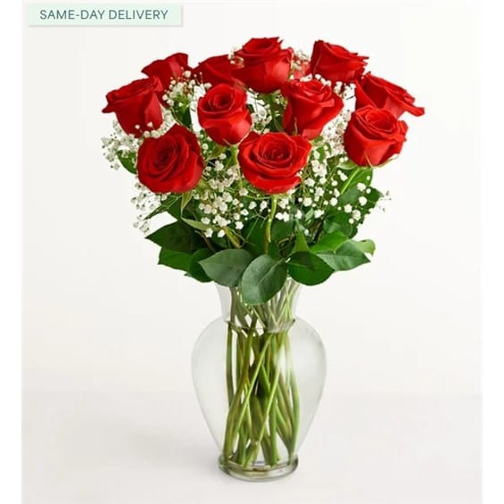 Bouquet of red roses with baby's breath in a clear glass vase