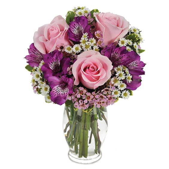 Pink roses and purple alstroemeria in a clear glass vase