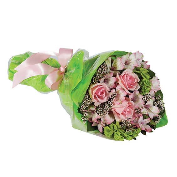 Pink roses and mixed blooms wrapped in green paper with a pink ribbon