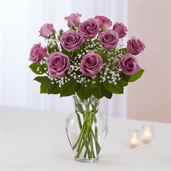 Pink roses in a clear glass vase with baby's breath