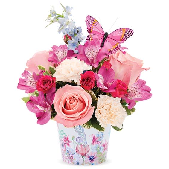 Pink and white flower bouquet in a floral-print container with a butterfly pick