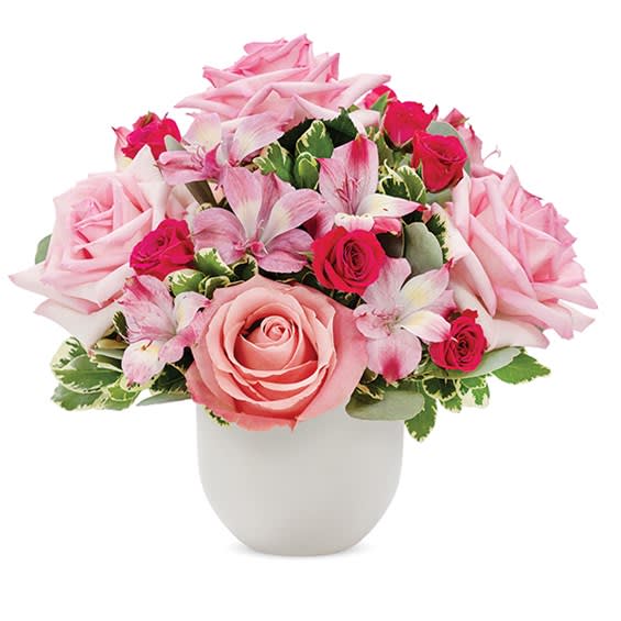 Pink roses and lilies arranged in a white vase