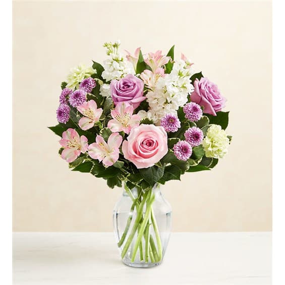Pink and lavender flowers arranged in a clear glass vase