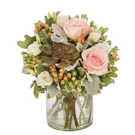 Pink roses and white blooms in a clear glass vase with succulents