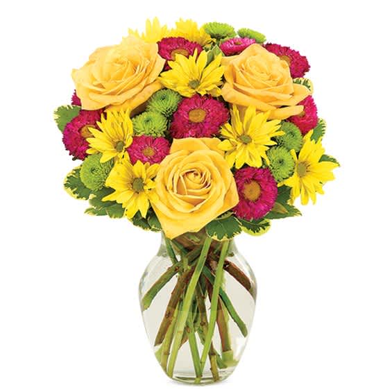 Yellow roses and mixed daisies in a clear glass vase