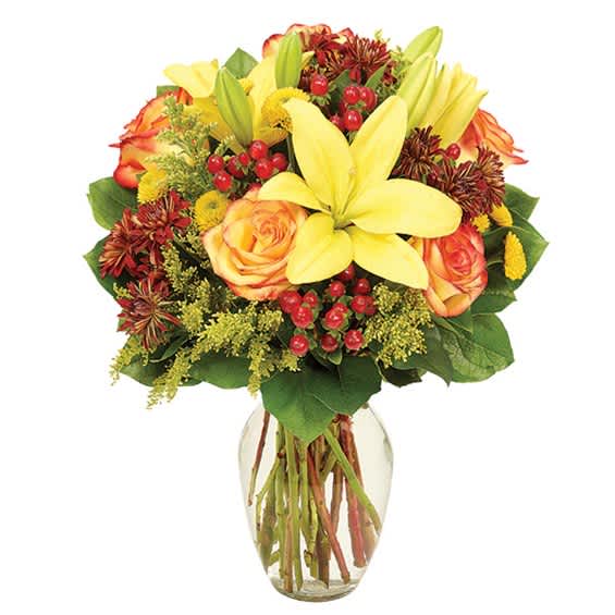 Bouquet of yellow lilies and orange roses in a clear glass vase