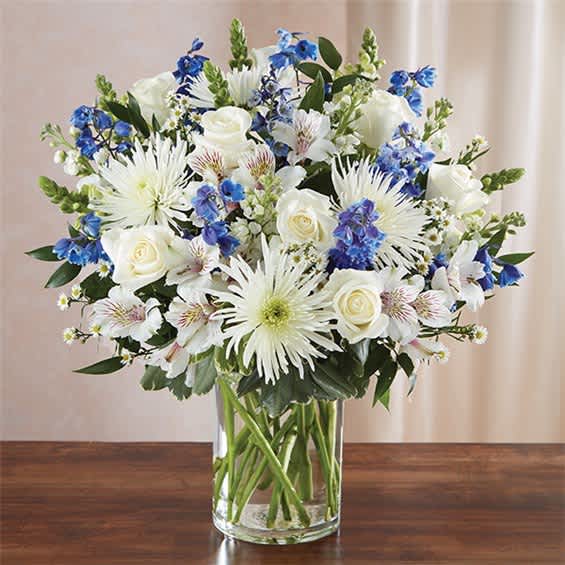 White and blue mixed bouquet in a clear glass vase