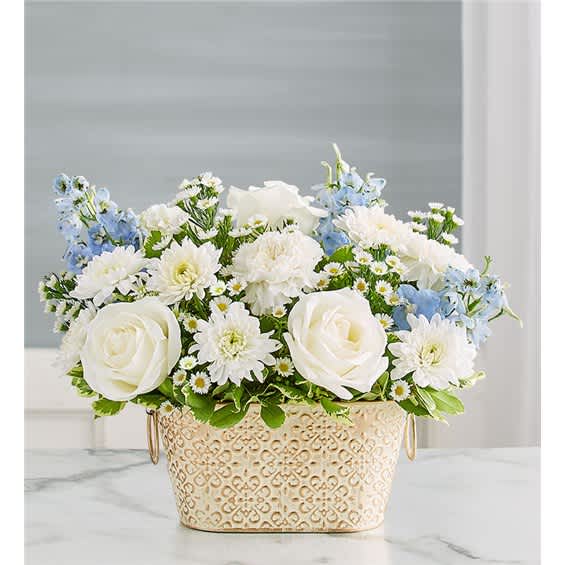 White roses and daisies with blue flowers in a decorative metal container