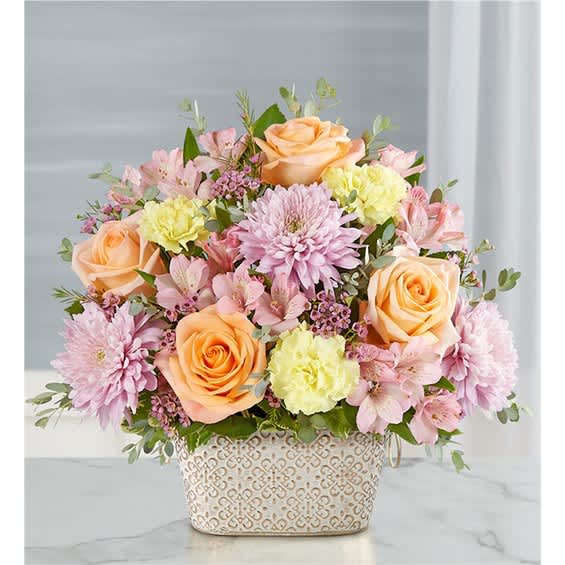 Pastel flower arrangement in a patterned ceramic container