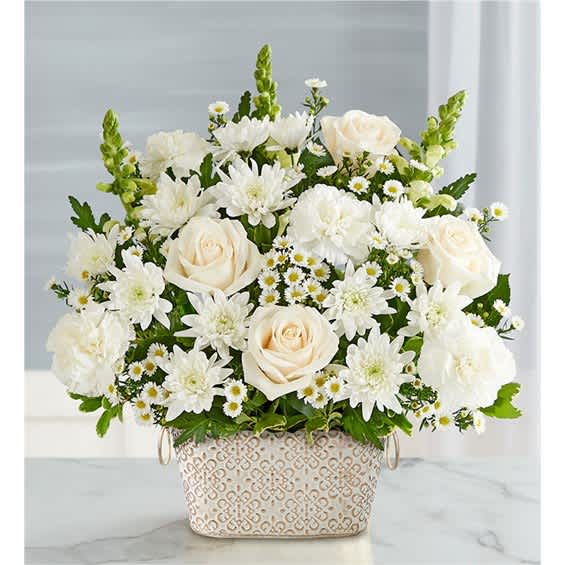 White roses and daisies arranged in a patterned basket