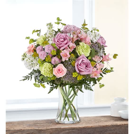 Bouquet of pink and lavender roses in a clear glass vase