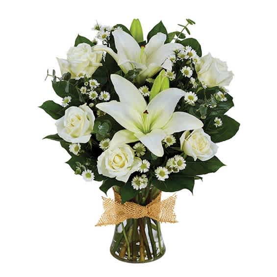 White lilies and roses in a glass vase with a burlap bow