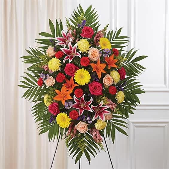 Large standing floral spray with roses, lilies, and daisies on an easel