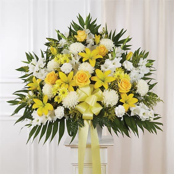 Yellow and white floral arrangement with a ribbon bow in a vase