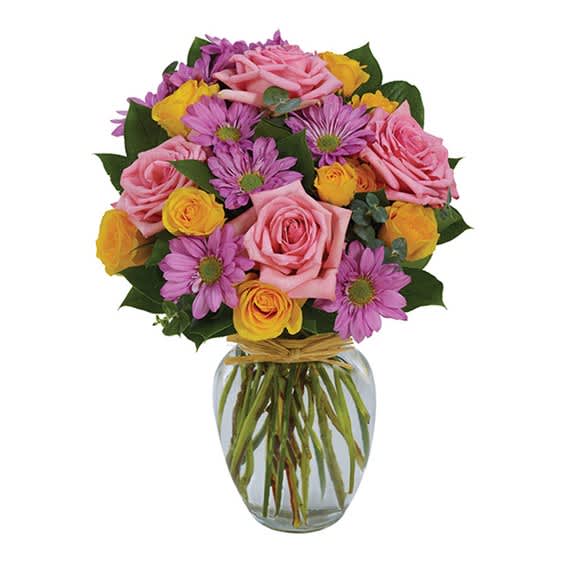 Bouquet of pink roses, purple daisies, and yellow roses in a glass vase