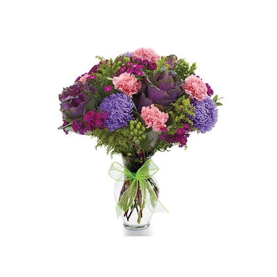 Mixed purple and pink bouquet in a clear glass vase with a green ribbon