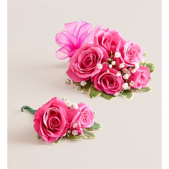 Pink rose corsage and boutonniere with small white filler flowers