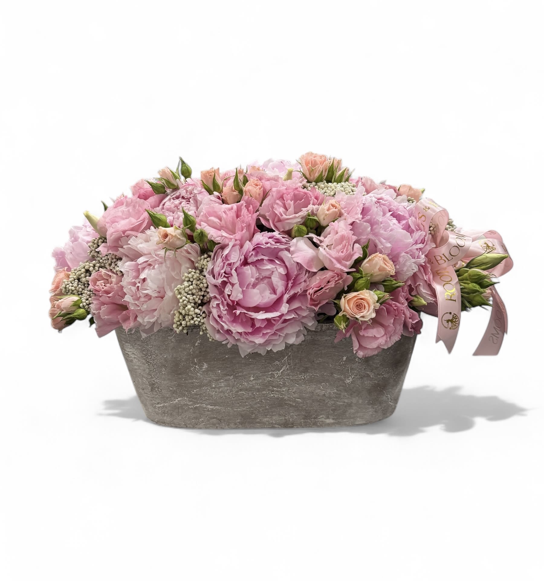 Pink floral arrangement in a gray rectangular container with a ribbon