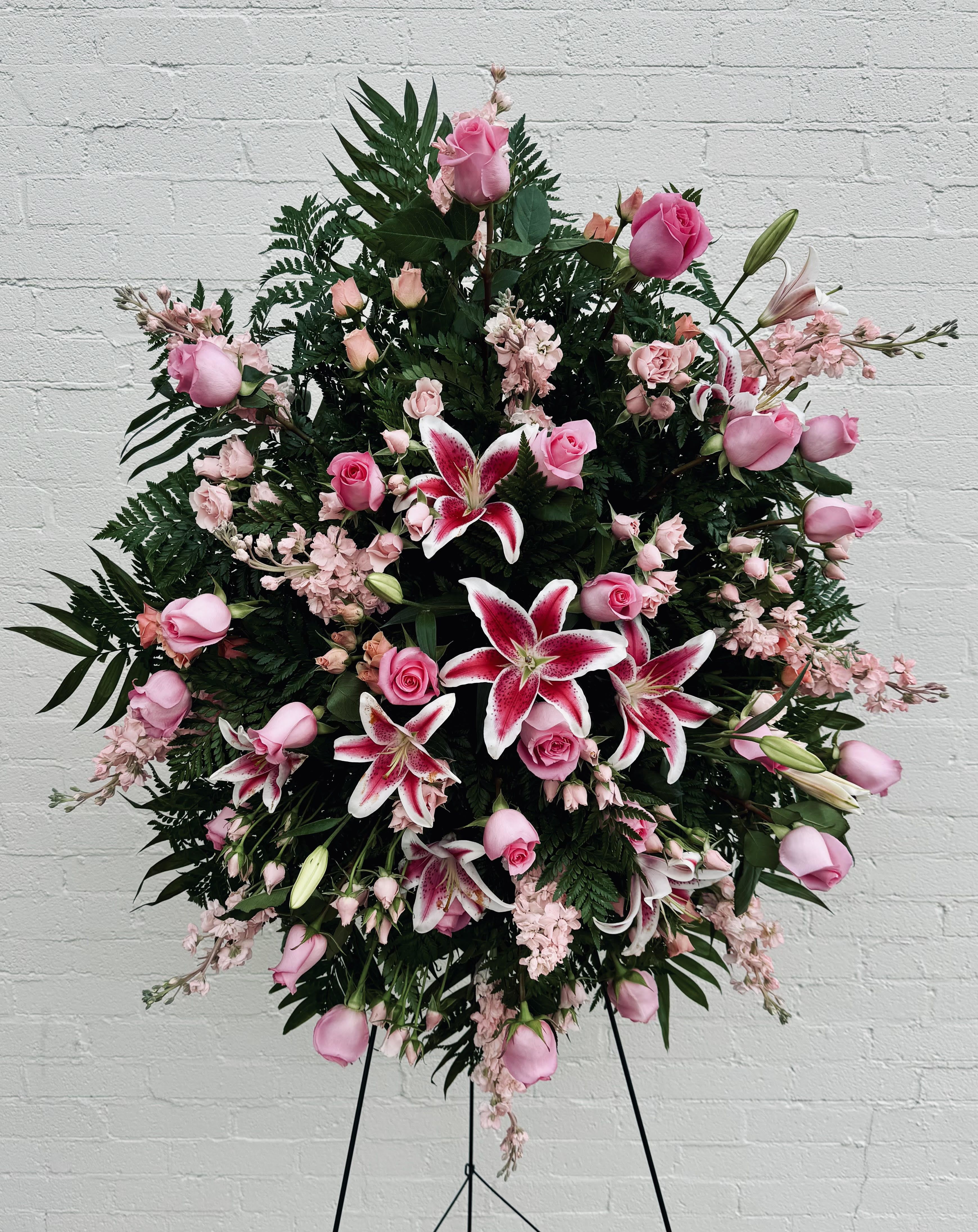 Pink Standing Spray  - Beautiful standing spray in shades of pinks and a mixture of different flowers such as roses, sweetheart roses, stargazer lilies, pink stock and greenery.  Send this beautiful pink standing spray to share your heartfelt condolences with the family. 30" W 18" H