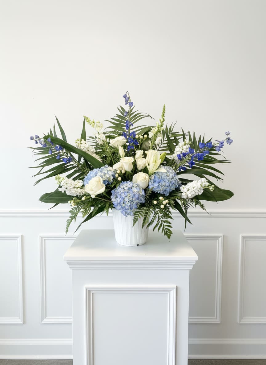 Towards Blue Skies - Traditional floor sympathy basket including hydrangea, roses, snapdragon, delphinium, stock and lizianthus.