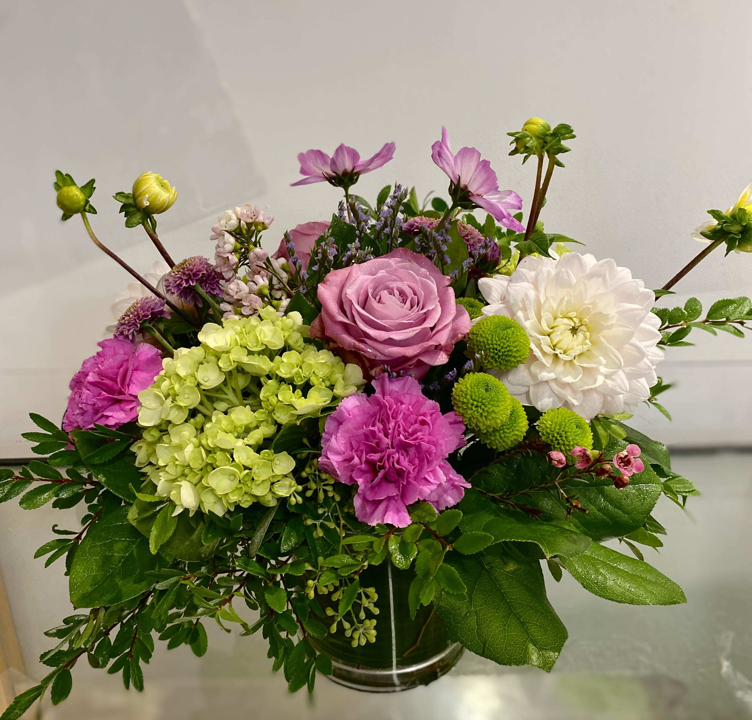Compact vase arrangement with pink rose, white dahlia, green hydrangea and bright pink carnations