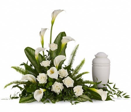 White calla lilies and roses arranged beside a white urn