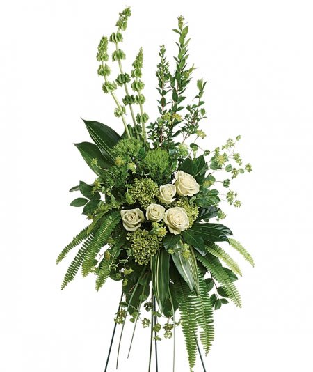Tall green and white standing arrangement with roses, bells of Ireland, and lush greenery.