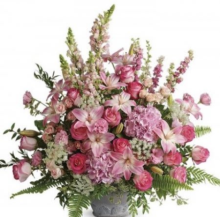 Tall pink arrangement of lilies, roses, and hydrangeas in a gray pedestal vase