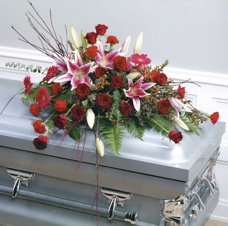 Red roses and pink lilies arranged on a silver casket