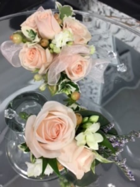 Wedding corsage of blush roses with white accents and ribbon in a compact double cluster design