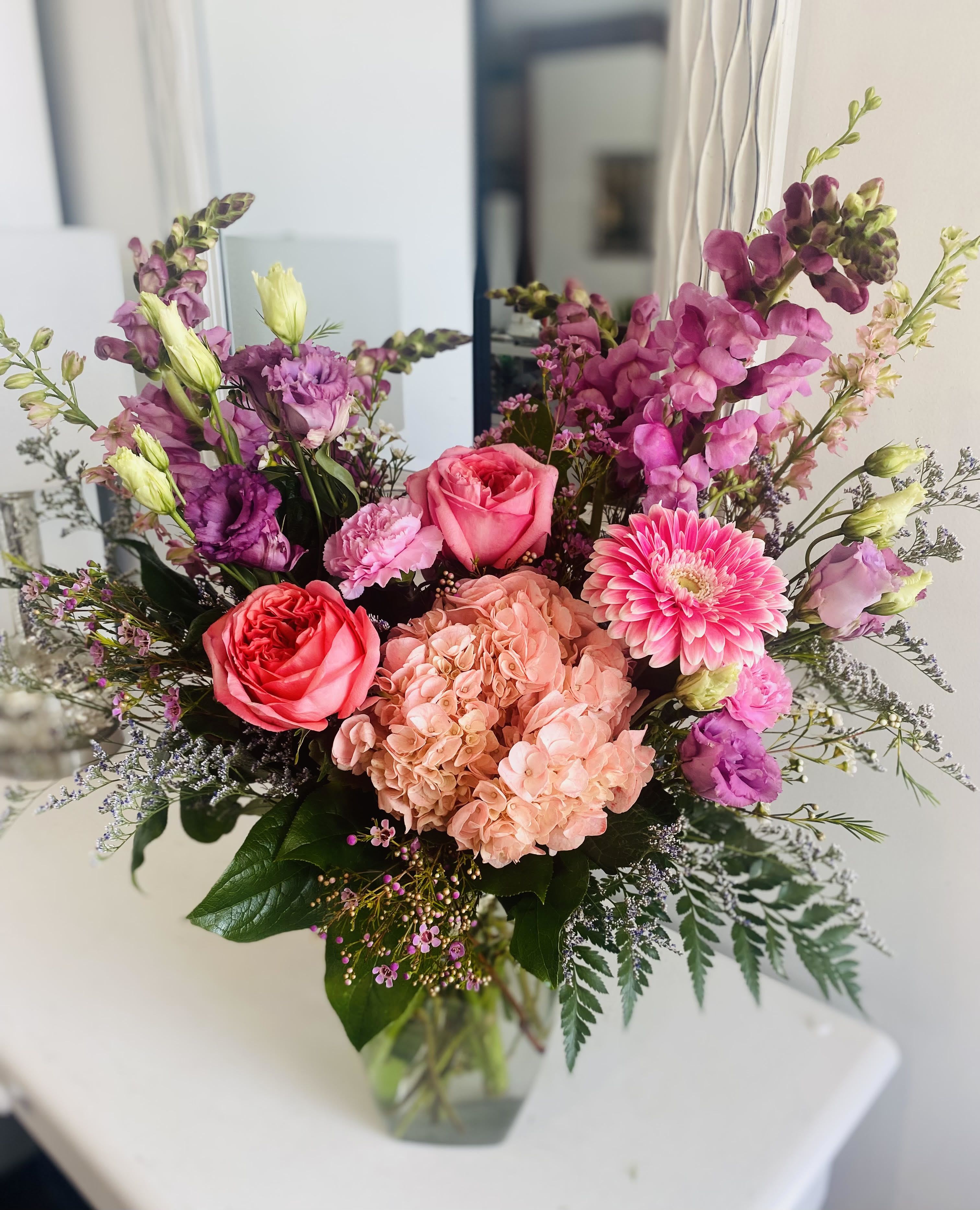 Mixed pink and purple bouquet in a clear glass vase
