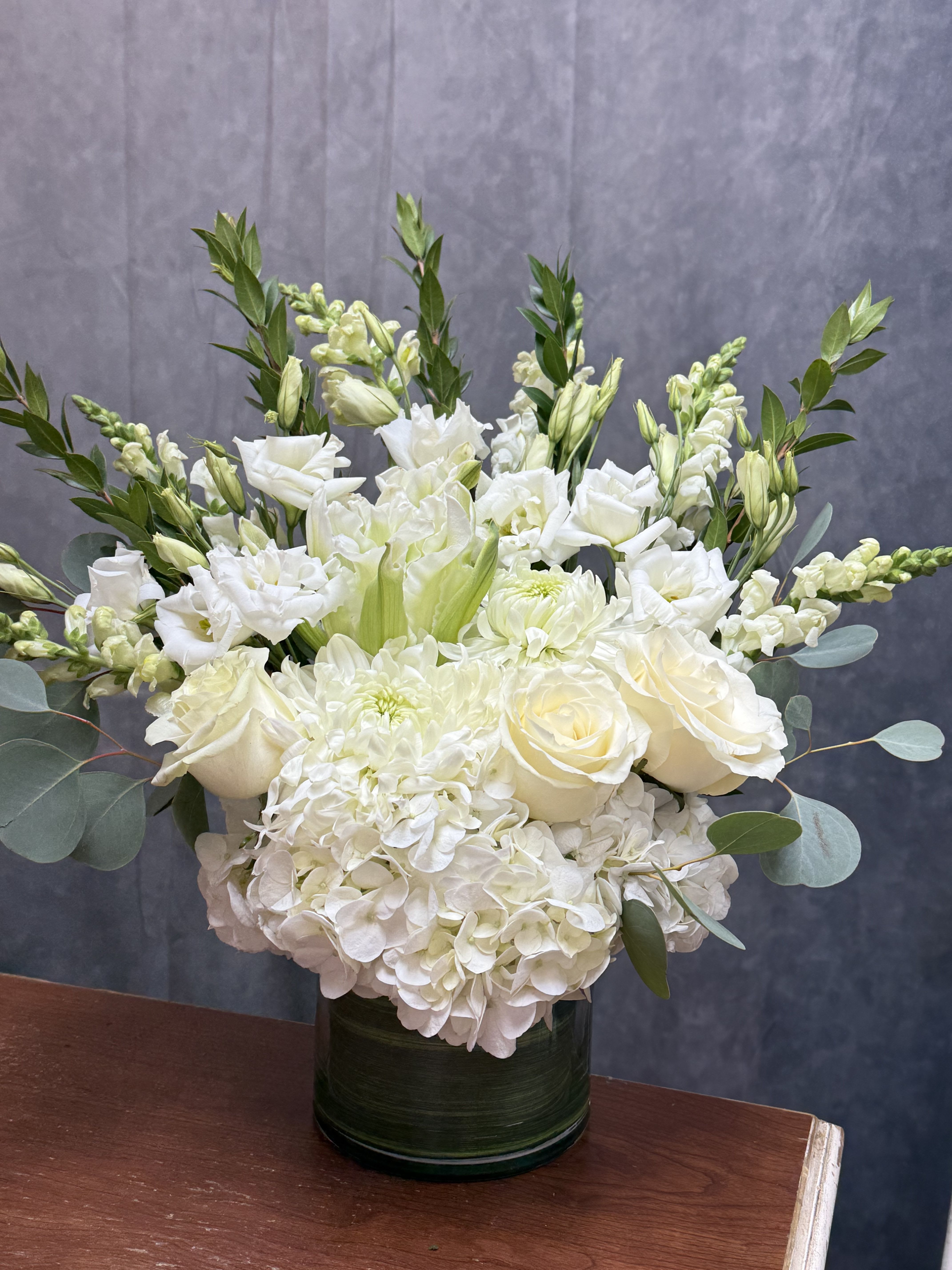 White floral arrangement in a dark green vase