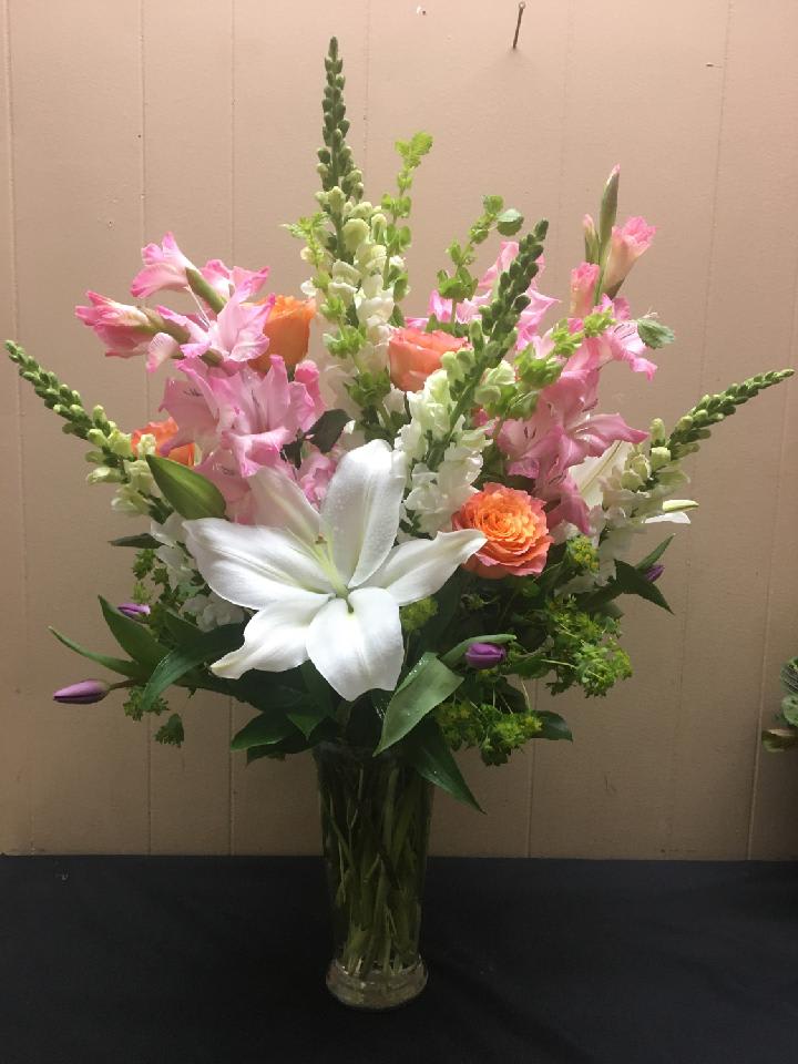 Tall bouquet of pink and white flowers in a clear glass vase