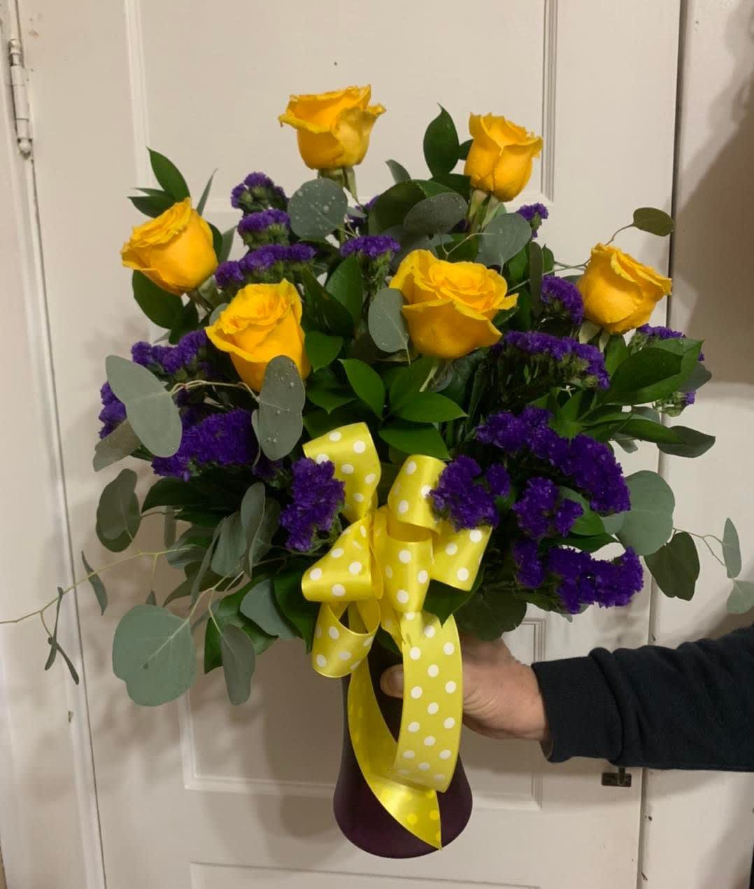 Bouquet of yellow roses and purple filler flowers with a yellow polka-dot ribbon