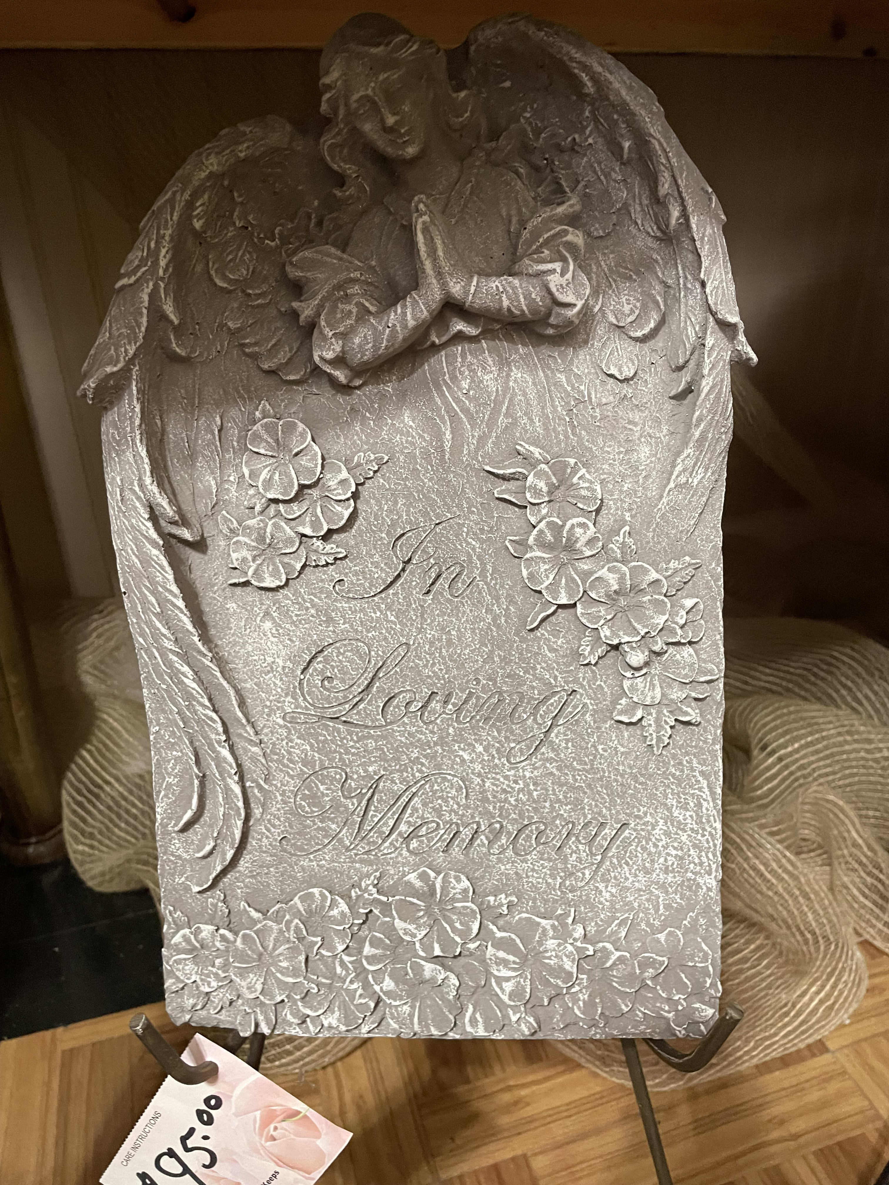 Silver memorial plaque with angel and floral relief reading "In Loving Memory"