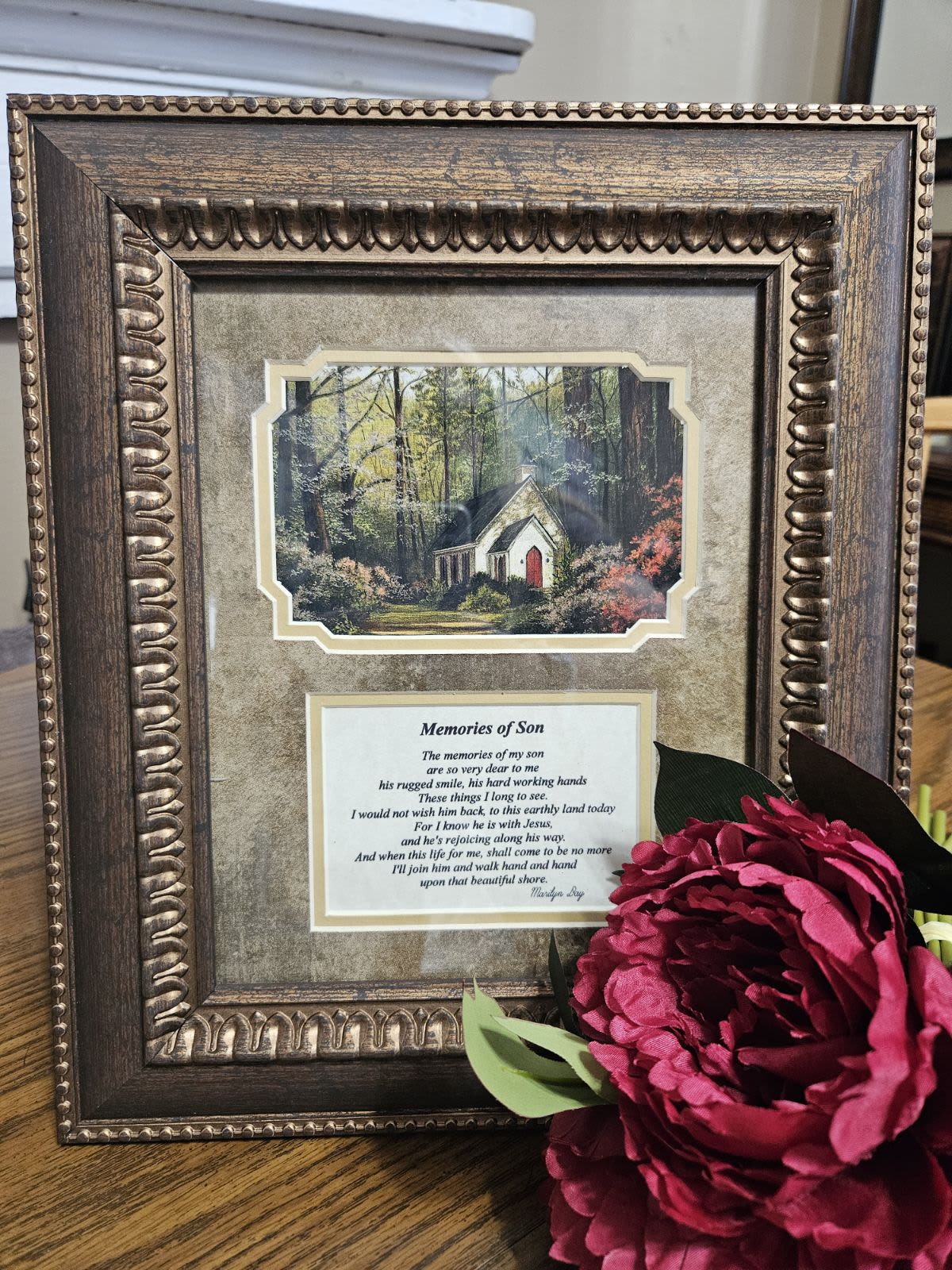 Framed memorial plaque with a pink flower accent