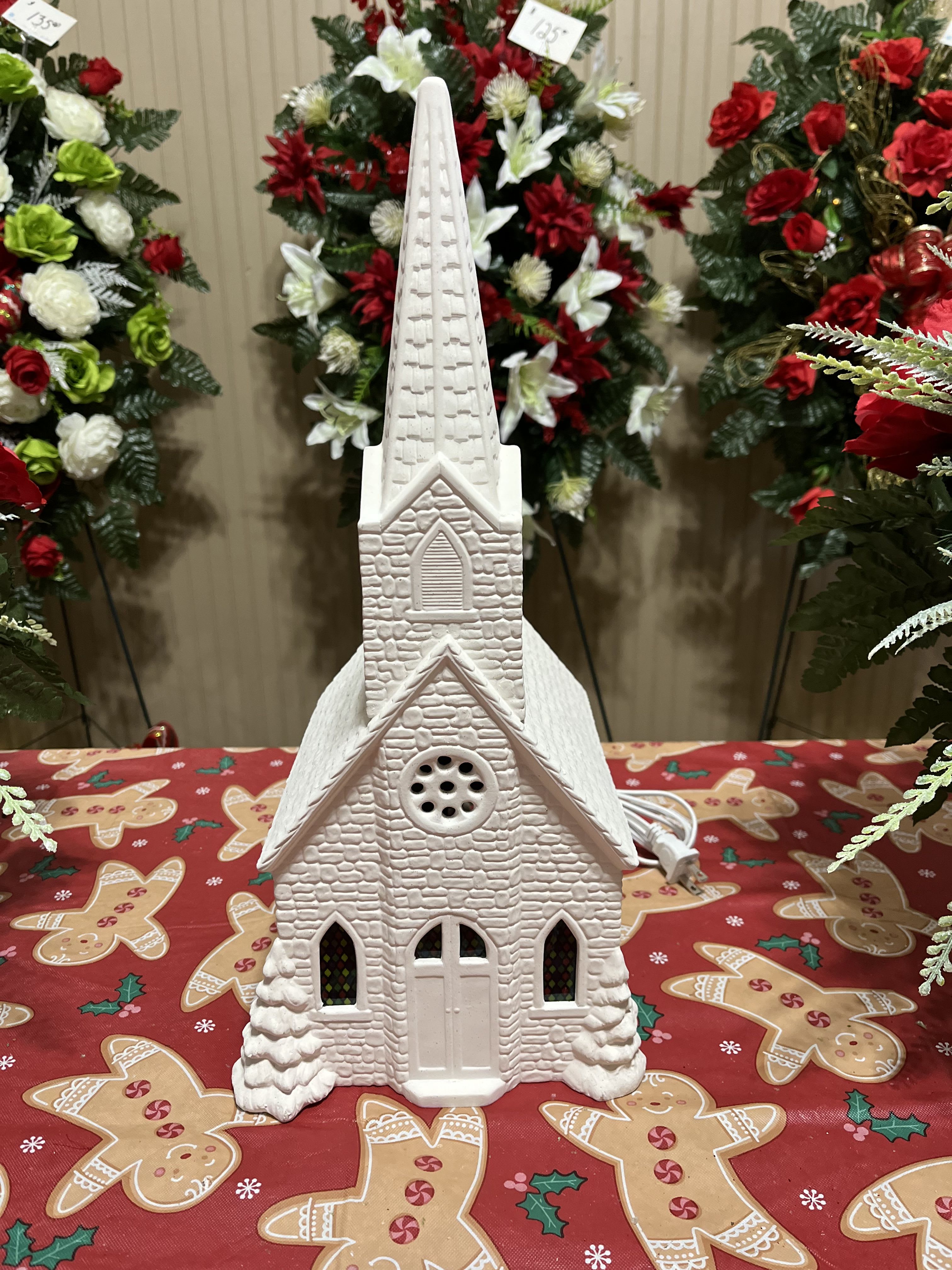 White church-shaped holiday decoration on a gingerbread tablecloth