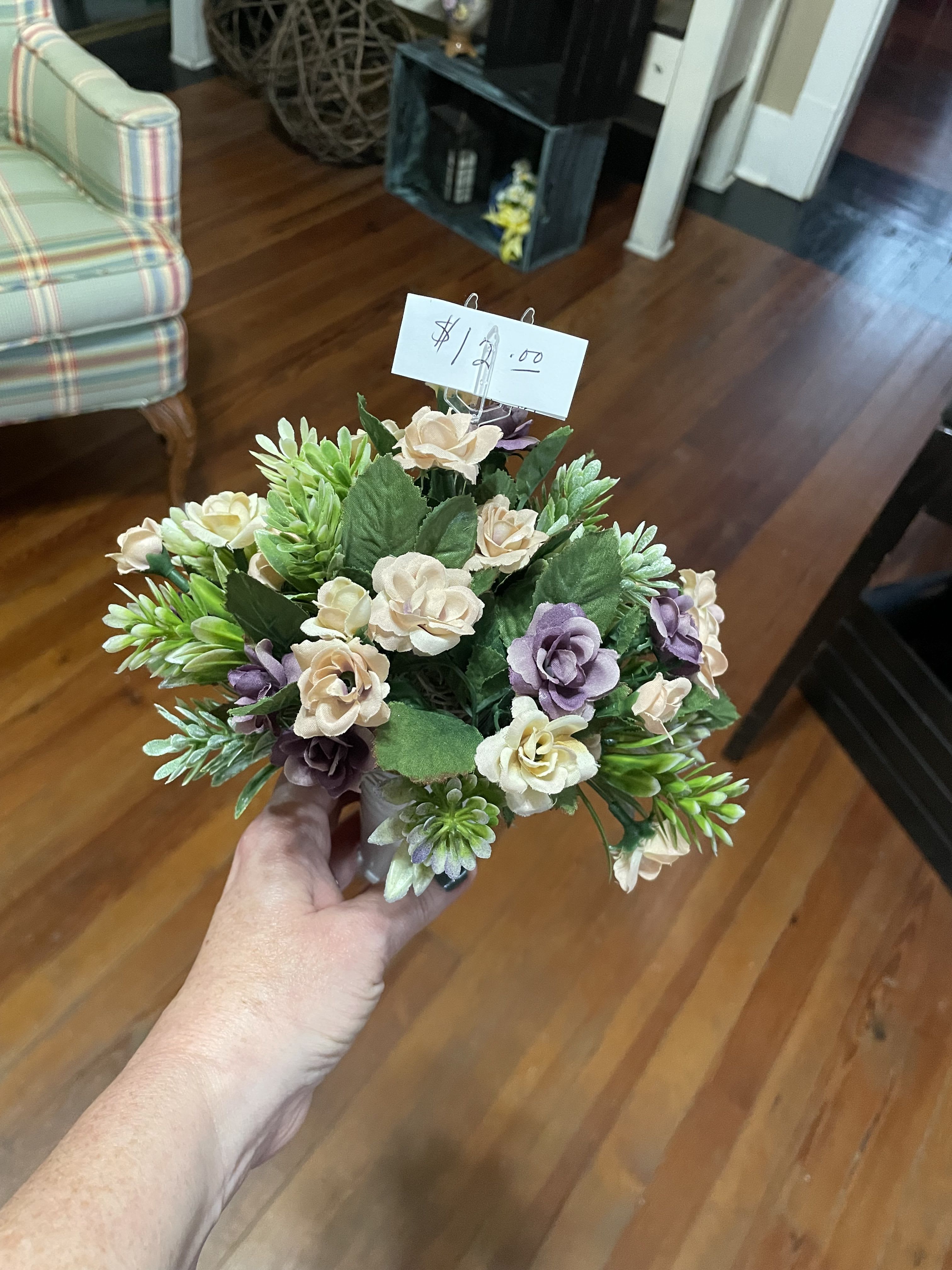 Small bouquet of cream and lavender flowers in a hand
