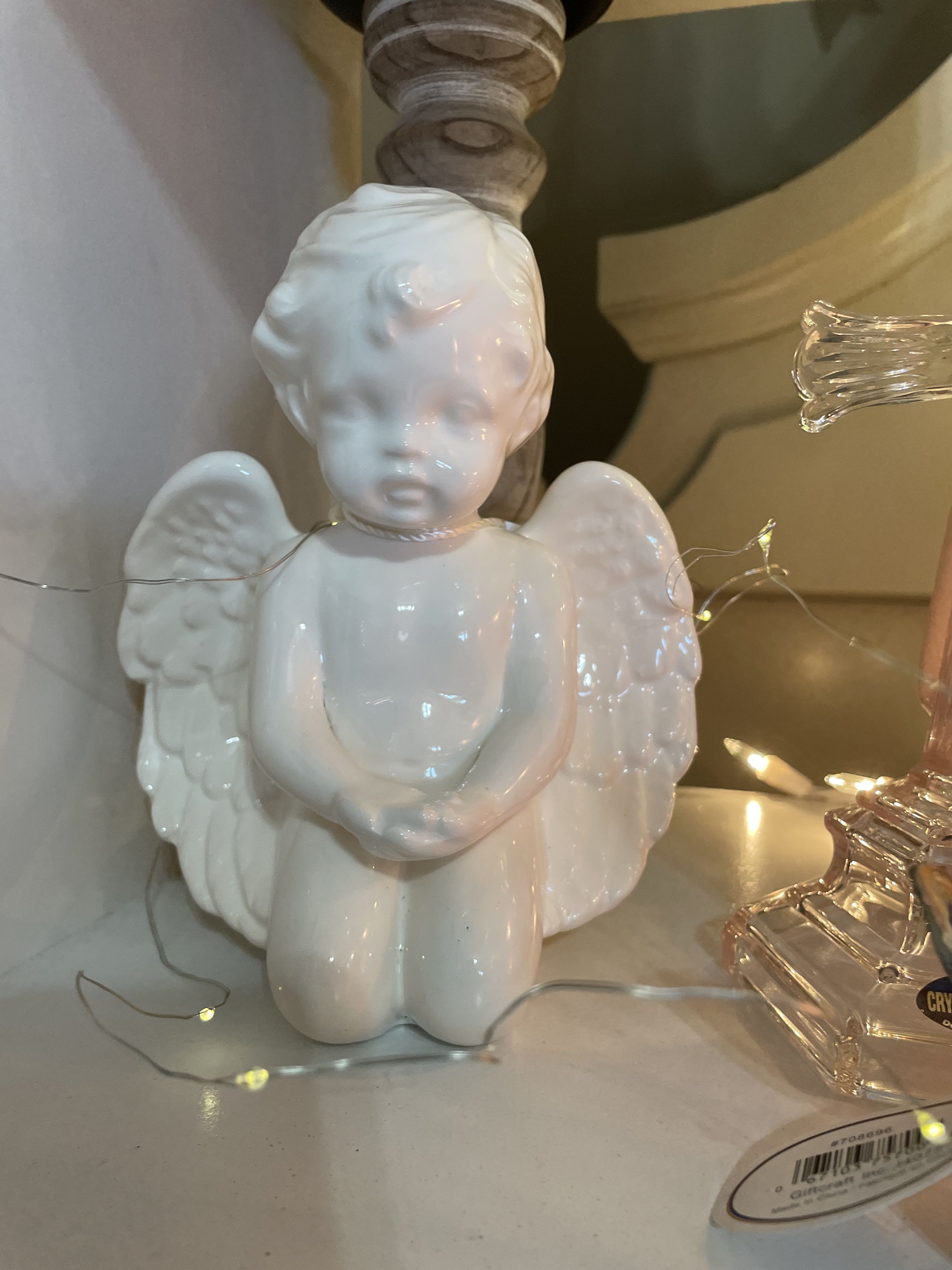 White ceramic angel figurine with wings and folded hands